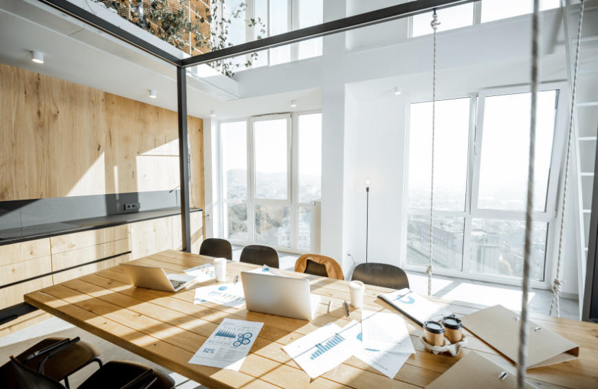 Espacio de trabajo con paredes acristaladas y luz natural en abundancia