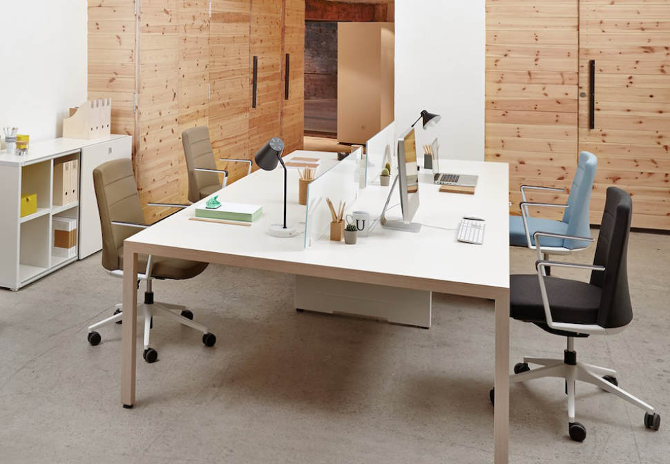 Mesa operativa blanca con separadores en oficina minimalista