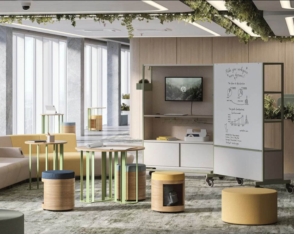 Espacio polivalente con mesas altas, taburetes y pizarra móvil